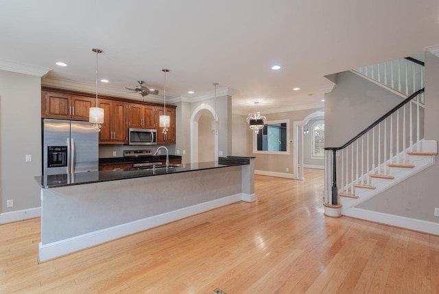 3277 Preston Shore Dr, Rockingham, VA 22801 - kitchen with appliances with stainless steel finishes, arched walkways, crown molding, dark countertops, and light wood-style flooring