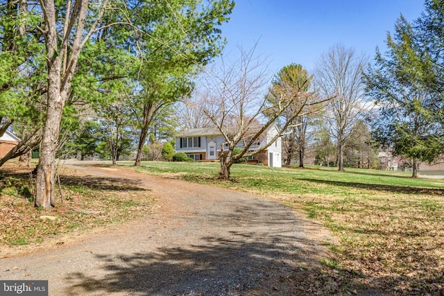 raised ranch with a front lawn and driveway
