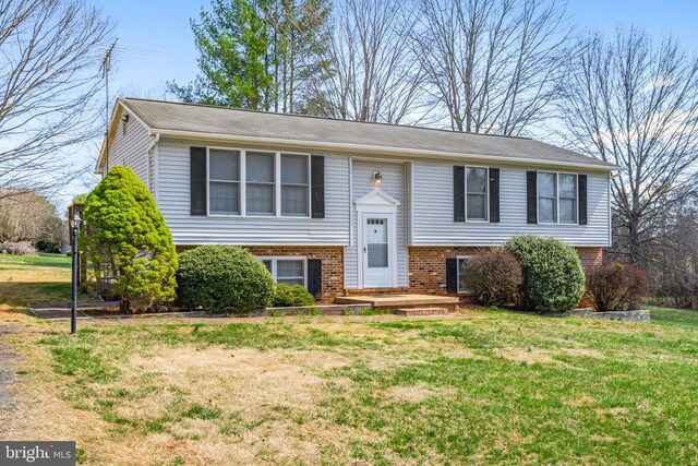 split foyer home with brick siding and a front lawn