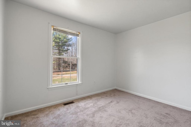 carpeted empty room featuring healthy amount of natural light and baseboards