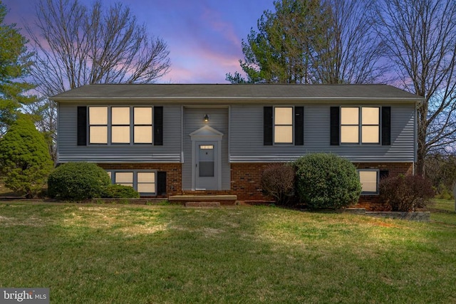 split foyer home featuring brick siding and a front yard