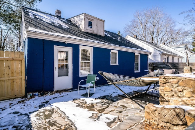 212 Shamrock Rd, Charlottesville, VA 22903 - snow covered rear of property with a chimney, a shingled roof, concrete block siding, and fence