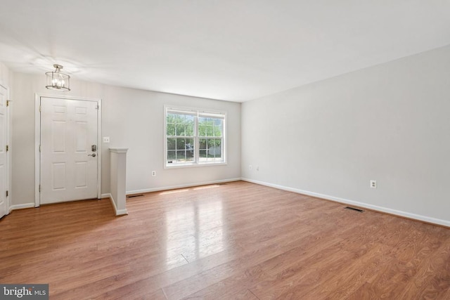 546 Highland Towne Ln, Warrenton, VA 20186 - unfurnished living room with a chandelier and light wood-style floors
