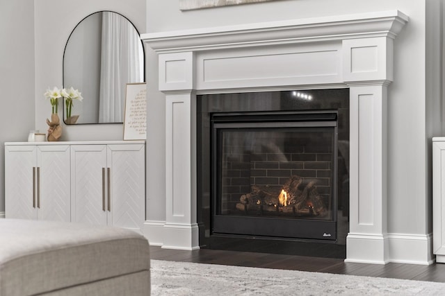 interior details featuring wood finished floors, a fireplace with flush hearth, and baseboards