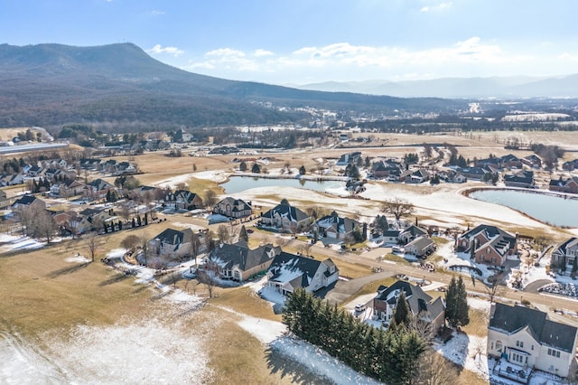 drone / aerial view featuring a water and mountain view and a residential view