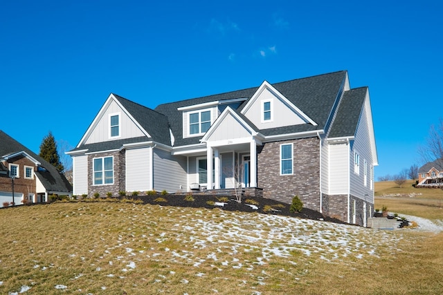 view of front of house featuring stone siding, a front lawn, a porch, and board and batten siding