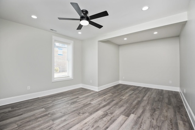 empty room featuring baseboards, visible vents, dark wood-style flooring, and recessed lighting