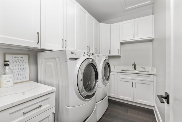 laundry room featuring cabinet space, dark wood-type flooring, separate washer and dryer, and a sink