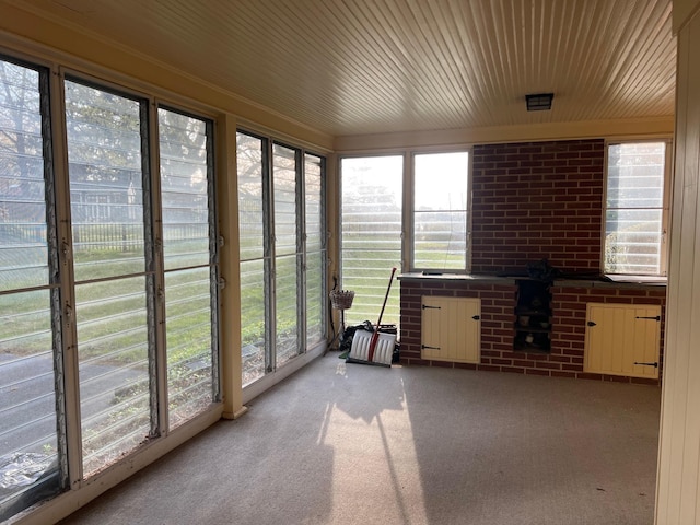 unfurnished sunroom with wooden ceiling and carpet floors