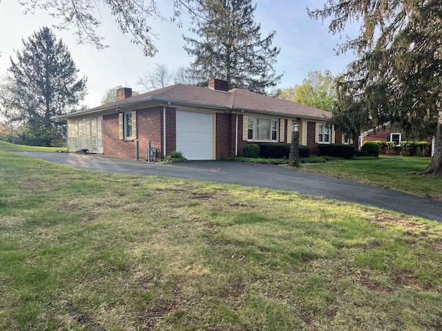 ranch-style home with brick siding, an attached garage, a chimney, and driveway