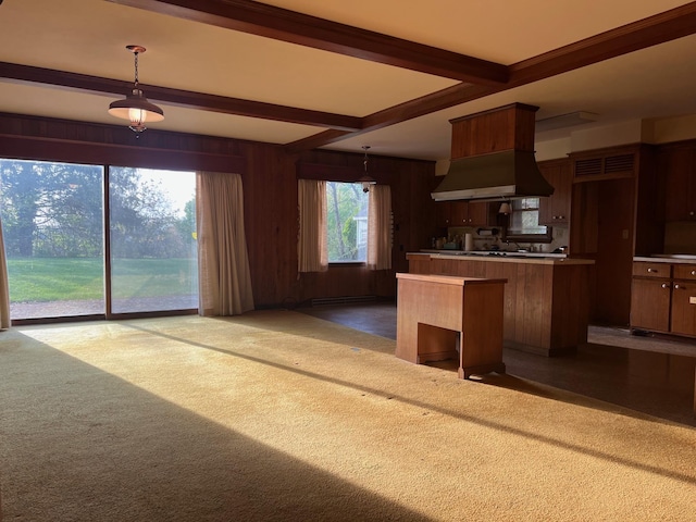 kitchen featuring extractor fan, wood walls, carpet, beamed ceiling, and hanging light fixtures