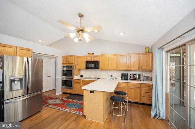 108 Harris Ct, Locust Grove, VA 22508 - kitchen featuring black appliances, lofted ceiling, a peninsula, wood finished floors, and light countertops