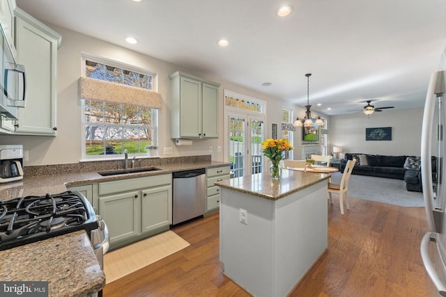kitchen with appliances with stainless steel finishes, a sink, a center island, french doors, and recessed lighting