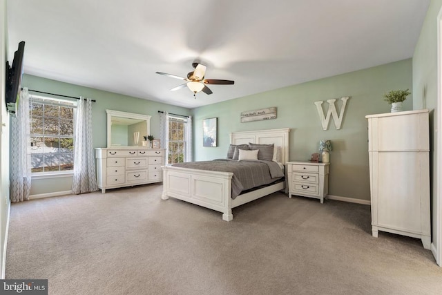 carpeted bedroom with multiple windows, baseboards, and a ceiling fan