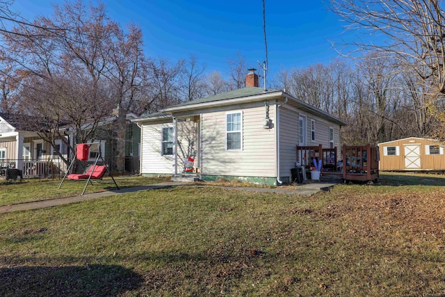608 Hawkins St, Harrisonburg, VA 22801 - view of front of house featuring a chimney, an outbuilding, a deck, a front lawn, and a storage unit