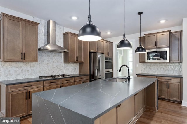 11207 Redlands Trl, Spotsylvania, VA 22551 - kitchen featuring wall chimney range hood, appliances with stainless steel finishes, a sink, dark wood-style floors, and decorative backsplash
