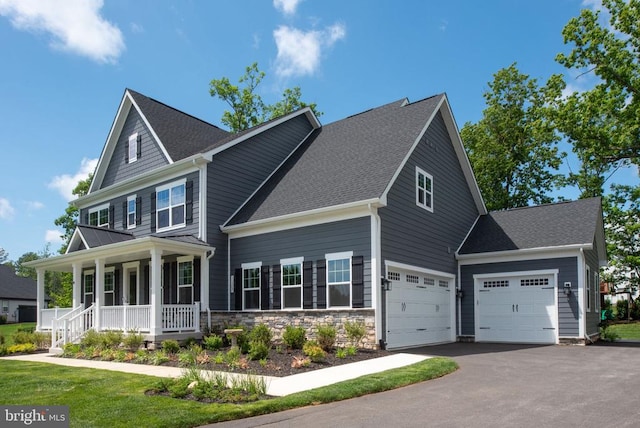 11207 Redlands Trl, Spotsylvania, VA 22551 - view of front facade with a porch, driveway, an attached garage, a shingled roof, and stone siding