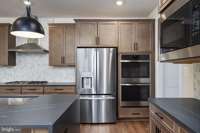 11207 Redlands Trl, Spotsylvania, VA 22551 - kitchen featuring appliances with stainless steel finishes, dark wood-style flooring, decorative backsplash, and hanging light fixtures