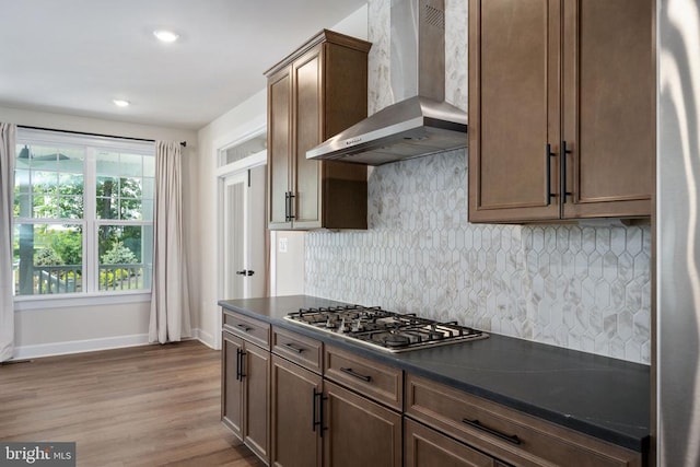 11207 Redlands Trl, Spotsylvania, VA 22551 - kitchen featuring wall chimney range hood, stainless steel gas cooktop, dark countertops, wood finished floors, and baseboards