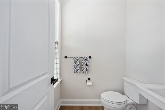 11207 Redlands Trl, Spotsylvania, VA 22551 - half bathroom featuring toilet, wood finished floors, baseboards, and a sink