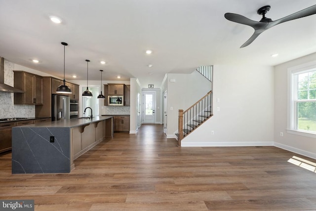 11207 Redlands Trl, Spotsylvania, VA 22551 - kitchen featuring appliances with stainless steel finishes, wall chimney exhaust hood, a sink, decorative backsplash, and dark countertops