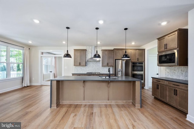 11207 Redlands Trl, Spotsylvania, VA 22551 - kitchen featuring stainless steel appliances, a sink, dark countertops, wall chimney exhaust hood, and recessed lighting
