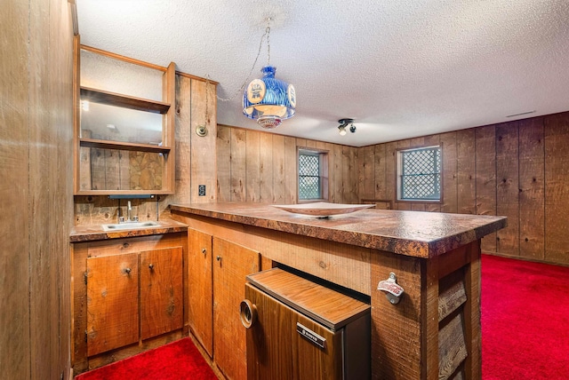 183 Deer Dr, Mcgaheysville, VA 22840 - kitchen featuring a textured ceiling, a peninsula, wooden walls, brown cabinets, and open shelves