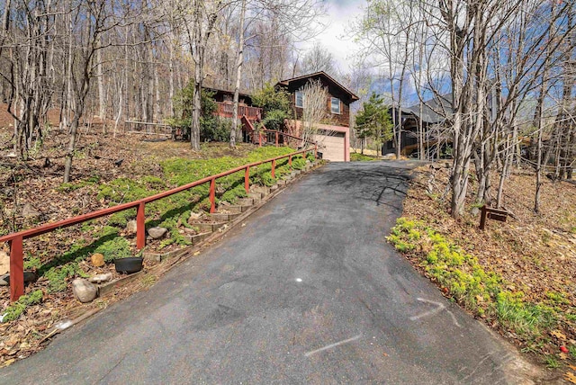 view of front of property featuring stairs, driveway, and an attached garage