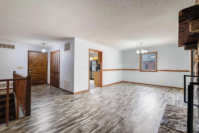 183 Deer Dr, Mcgaheysville, VA 22840 - unfurnished living room featuring wood finished floors, a chandelier, and a textured ceiling
