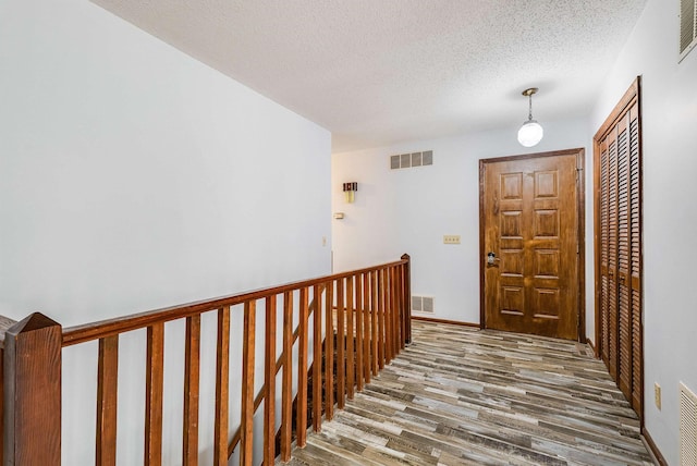 183 Deer Dr, Mcgaheysville, VA 22840 - corridor with wood finished floors, a textured ceiling, and an upstairs landing