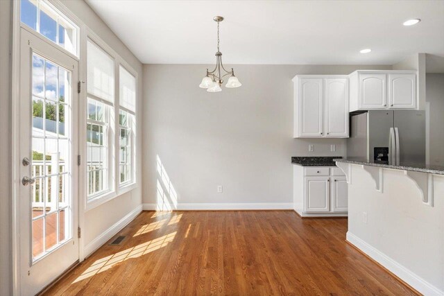 239 Windsor Dr, Fishersville, VA 22939 - kitchen featuring stainless steel fridge, wood finished floors, a chandelier, white cabinetry, and a breakfast bar area