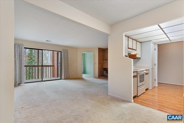 kitchen featuring light colored carpet, white range with electric cooktop, a textured ceiling, baseboards, and under cabinet range hood