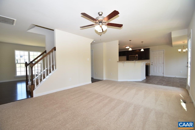 1193 Shenandoah Crossing Dr, Gordonsville, VA 22942 - unfurnished living room with light colored carpet, ceiling fan, stairway, and a chandelier