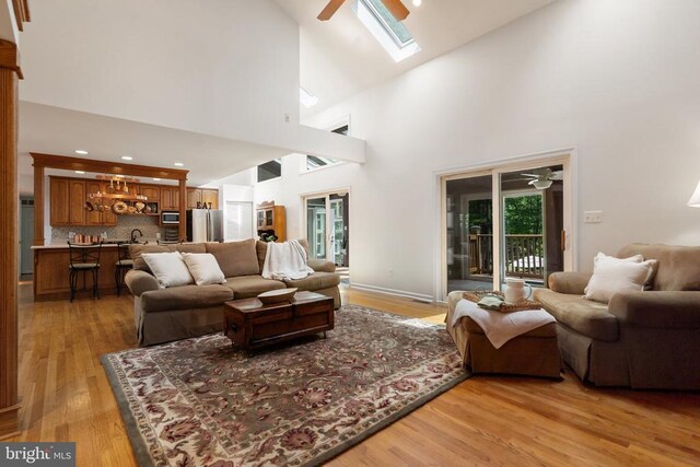 13013 Alum Springs Rd, Culpeper, VA 22701 - living room featuring a ceiling fan, light wood-type flooring, high vaulted ceiling, and a skylight