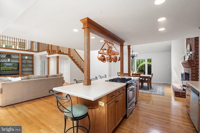 13013 Alum Springs Rd, Culpeper, VA 22701 - kitchen featuring appliances with stainless steel finishes, a kitchen breakfast bar, open floor plan, light countertops, and light wood-style floors