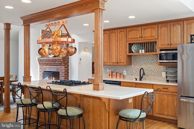 13013 Alum Springs Rd, Culpeper, VA 22701 - kitchen featuring appliances with stainless steel finishes, light wood finished floors, a kitchen island, backsplash, and a kitchen breakfast bar