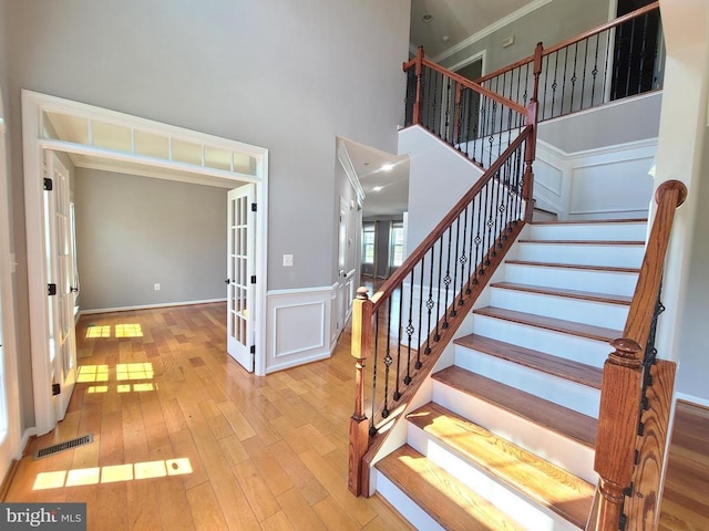 9423 Reservoir Rd, Fredericksburg, VA 22407 - stairway with wood finished floors, french doors, crown molding, a high ceiling, and wainscoting