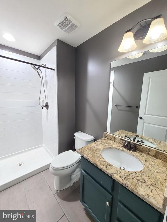 9423 Reservoir Rd, Fredericksburg, VA 22407 - full bathroom with vanity, a stall shower, and toilet