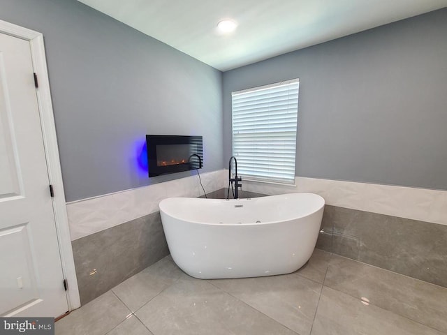 9423 Reservoir Rd, Fredericksburg, VA 22407 - bathroom with tile walls, a freestanding tub, tile patterned flooring, a wainscoted wall, and a glass covered fireplace