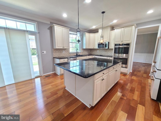 9423 Reservoir Rd, Fredericksburg, VA 22407 - kitchen with stainless steel appliances, a sink, crown molding, tasteful backsplash, and a center island