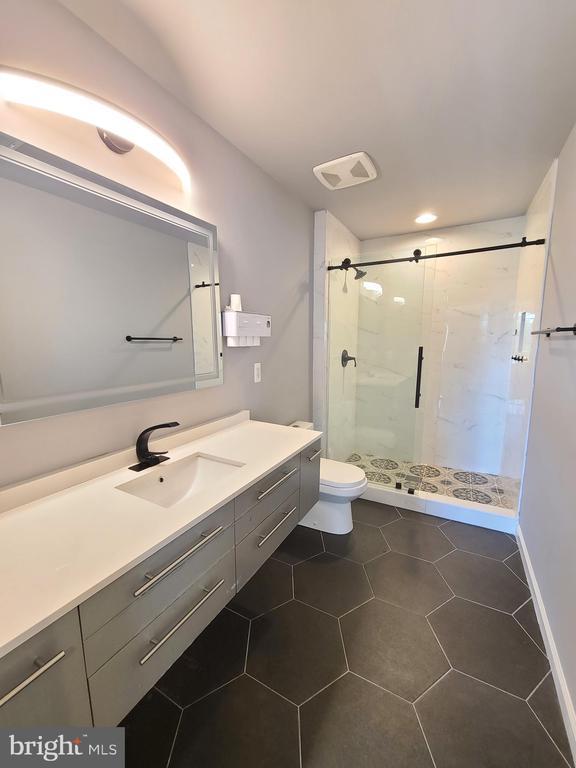 9423 Reservoir Rd, Fredericksburg, VA 22407 - bathroom featuring a stall shower, vanity, toilet, and tile patterned floors