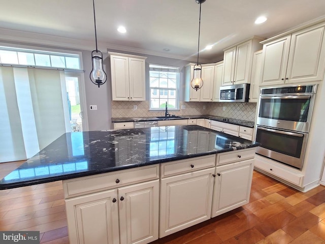 9423 Reservoir Rd, Fredericksburg, VA 22407 - kitchen featuring stainless steel appliances, decorative backsplash, a kitchen island, crown molding, and pendant lighting