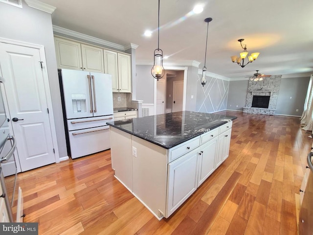 9423 Reservoir Rd, Fredericksburg, VA 22407 - kitchen featuring white refrigerator with ice dispenser, ornamental molding, light wood-style floors, hanging light fixtures, and backsplash