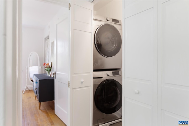 laundry room with estacked washer and dryer and light wood-type flooring