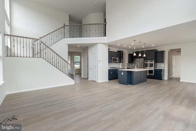 9003 Walnut Hill Rd, Fredericksburg, VA 22408 - unfurnished living room featuring stairs, a high ceiling, light wood finished floors, and recessed lighting