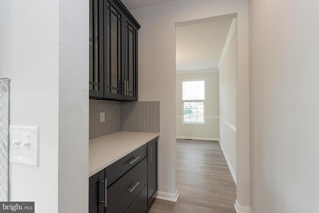 9003 Walnut Hill Rd, Fredericksburg, VA 22408 - bar area with decorative backsplash, light wood-type flooring, and crown molding