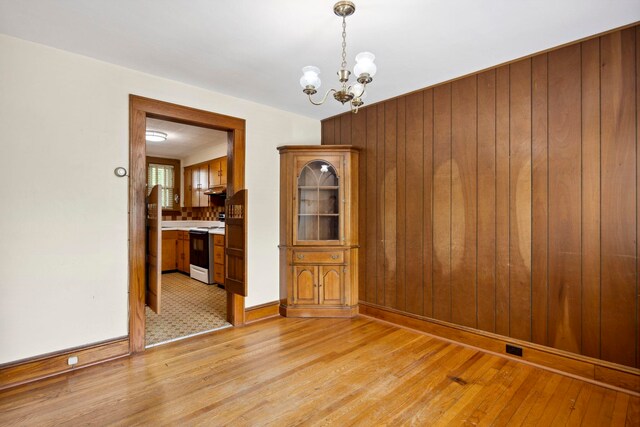 917 Chestnut Dr, Harrisonburg, VA 22801 - unfurnished room with wooden walls, light wood-style flooring, a chandelier, and baseboards