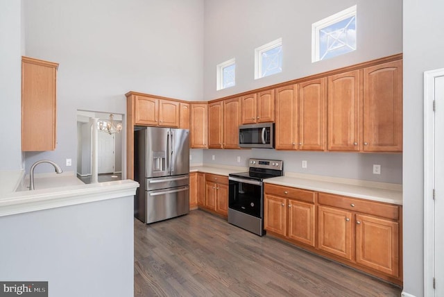 6304 Dranesville Dr W, Fredericksburg, VA 22407 - kitchen with appliances with stainless steel finishes, a towering ceiling, dark wood-style floors, light countertops, and a chandelier