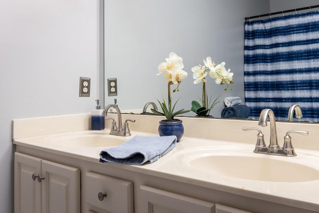 full bathroom with double vanity and a sink