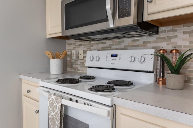 kitchen with electric stove, stainless steel microwave, light countertops, and decorative backsplash